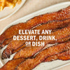 Image of candied bacon strips on a white plate, suggesting it can elevate any dessert, drink, or dish.
