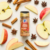 A bottle of McCormick Apple Cider spice blend is surrounded by apple slices, cinnamon sticks, and star anise.