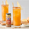 Two glasses of apple cider cocktails rimmed with McCormick Apple Pie Spice are garnished with apple slices.