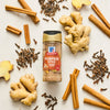 A jar of McCormick Pumpkin Spice is surrounded by cinnamon sticks, cloves, and ginger root.