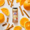 A bottle of McCormick Spiced Orange seasoning is surrounded by orange slices and cinnamon sticks.