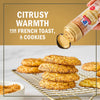 McCormick Citrusy Warmth seasoning is sprinkled on a stack of cookies on a wire rack, suggesting its use on French toast and cookies.