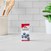 A box of Mccormick Blueberry Extract 1 Fl Oz With Other Natural Flavors stands on a white marble countertop in a kitchen setting.