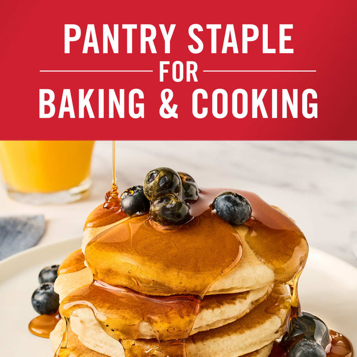 A stack of pancakes with blueberries and syrup is shown highlighting its versatility as a pantry staple for baking and cooking.