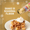 A hand sprinkles McCormick Pumpkin Pie Spice onto waffles topped with whipped cream, highlighting a seasonal flavor.
