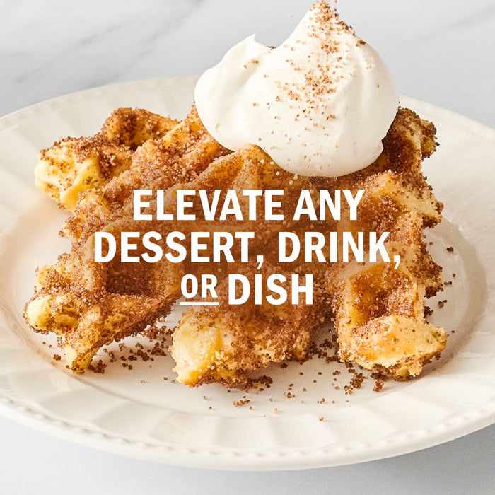 A waffle dessert topped with whipped cream and cinnamon, suggesting it can elevate any dessert, drink, or dish.