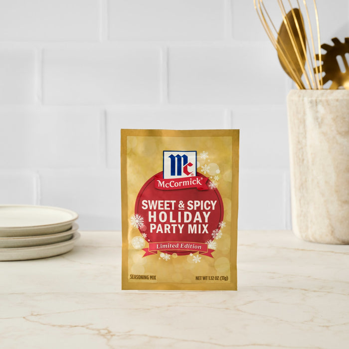 A packet of McCormick Sweet &amp; Spicy Holiday Party Mix sits on a countertop.
