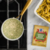 A packet of McCormick Green Bean Casserole seasoning mix is displayed next to a pan of the seasoning being prepared and a casserole dish of cooked green beans.