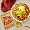A bowl of pumpkin chili with toppings next to a McCormick Pumpkin Chili seasoning packet.