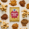 A packet of McCormick Brown Sugar Ham Glaze is surrounded by piles of brown sugar in various forms.