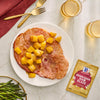 A plate of ham with pineapple chunks and McCormick Brown Sugar Ham Glaze, suggesting a delicious and easy meal.