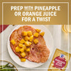 A plate of ham with pineapple chunks and a McCormick Ham Glaze packet, suggesting to prep with pineapple or orange juice for a twist.