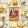 A packet of McCormick Brown Butter Gravy mix is surrounded by butter, garlic, and onions.