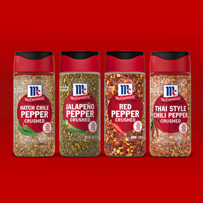 Four jars of McCormick crushed pepper including Hatch Chile JalapeA?o Red Pepper and Thai Style Chili Pepper are displayed against a red background.