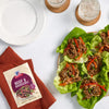 A packet of McCormick Beef &amp; Broccoli seasoning mix is displayed next to lettuce wraps filled with beef and vegetables.