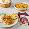 A plate of butter chicken with rice and naan bread is displayed next to a McCormick Butter Chicken seasoning mix packet.