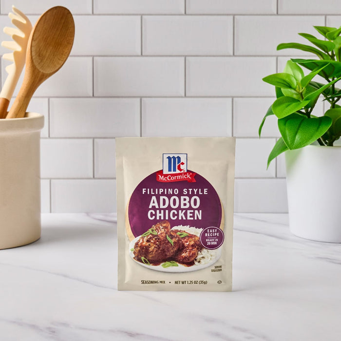 A packet of McCormick Filipino Style Adobo Chicken seasoning mix sits on a kitchen counter.