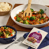 A serving of McCormick Filipino Style Adobo Chicken is displayed with rice and vegetables.