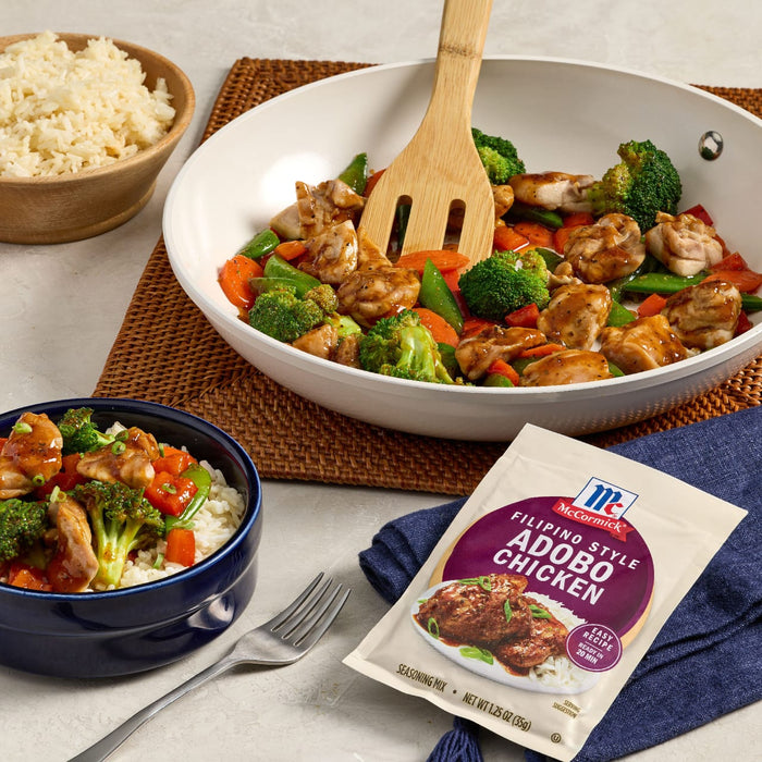 A serving of McCormick Filipino Style Adobo Chicken is displayed with rice and vegetables.