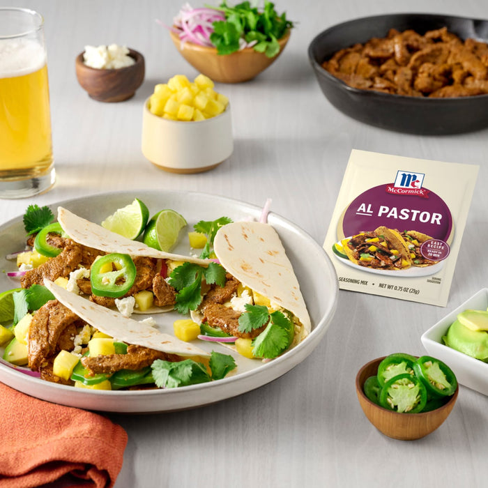 A plate of Al Pastor tacos with a packet of McCormick Al Pastor seasoning mix.
