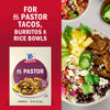 McCormick Al Pastor seasoning mix is advertised for tacos burritos and rice bowls with a photo of a rice bowl featuring the seasoned meat rice black beans pico de gallo pineapple avocado and queso fresco.