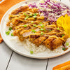 A plate of Japanese food with breaded chicken rice cabbage and pickled ginger.