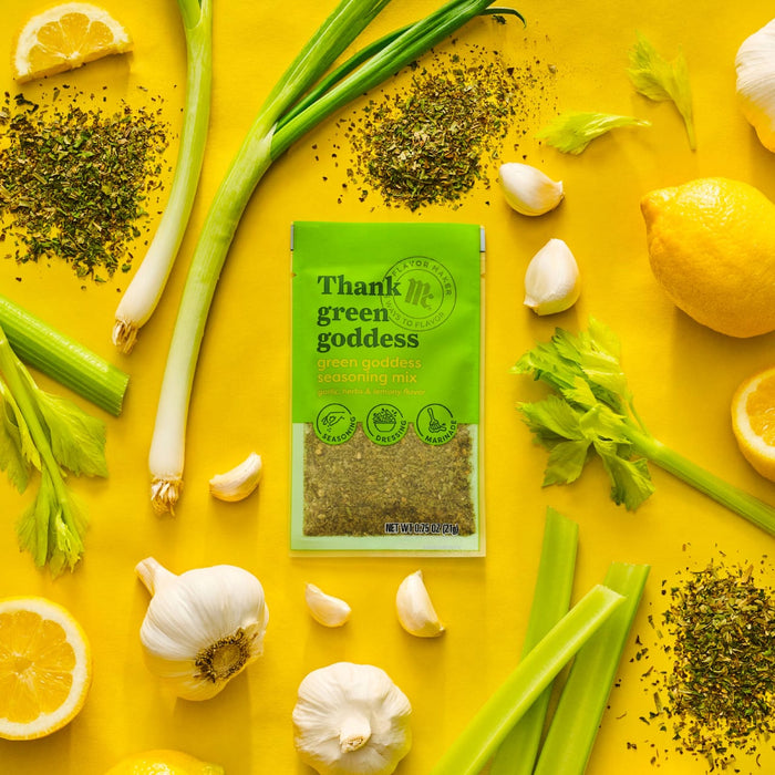A packet of Trader Joes Green Goddess seasoning is surrounded by fresh ingredients like lemon garlic celery and green onions highlighting the products natural and flavorful composition.