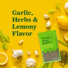 A packet of Thank Goodness Foods Garlic Herbs &amp; Lemony Flavor seasoning is displayed amidst fresh garlic cloves lemon slices and herbs highlighting its key ingredients.