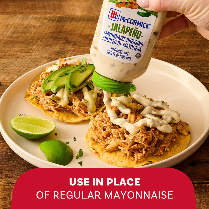 A hand squeezes McCormick Jalapeno Mayonnaise Dressing onto shredded chicken tostadas garnished with avocado and lime on a white plate above a red banner stating use in place of regular mayonnaise.