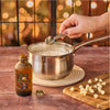A hand pours McCormick Harry Potter Butterbeer Flavoring into a pot of melted white chocolate.