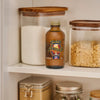 A bottle of McCormick Harry Potter Butterbeer Naturally and Artificially Flavored Flavor sits on a shelf among jars of sugar.