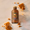 A bottle of Harry Potter Butterbeer Flavor by McCormick is surrounded by pieces of butterscotch candy.