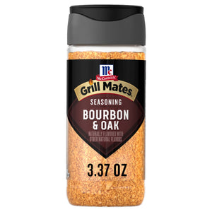 A clear plastic bottle of Mccormick Grill Mates Gm Bourbon &amp; Oak 3.37 Oz seasoning with a black label and cap, filled with light brown granular spice.