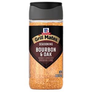 A clear plastic bottle of Mccormick Grill Mates Gm Bourbon &amp; Oak 3.37 Oz seasoning with a black label and cap, filled with light brown granular spice.