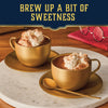 Two golden cups of hot chocolate with whipped cream are finished with a sweet sprinkle of Mccormick Harry Potter Cauldron Cake Finishing Sugar, 3.43 Oz, creating a cozy and inviting treat.