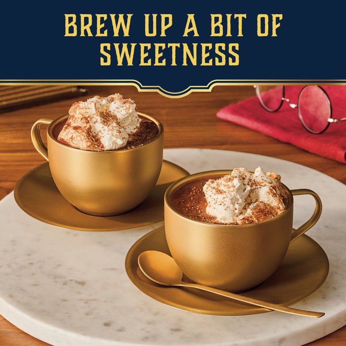 Two golden cups of hot chocolate with whipped cream are finished with a sweet sprinkle of Mccormick Harry Potter Cauldron Cake Finishing Sugar, 3.43 Oz, creating a cozy and inviting treat.