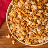 A bowl of popcorn and cereal snack mix is generously sprinkled with Mccormick Harry Potter Licorice Wand Finishing Sugar, 3.39 Oz, creating a sweet and savory treat.