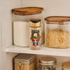 A bottle of Harry Potter Butterbeer Artificially Flavored Finishing Sugar by McCormick sits on a shelf among jars of sugar.