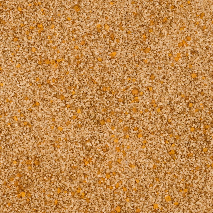 A close-up shows a granular mixture of light brown sugar crystals interspersed with small, irregularly shaped pieces of orange zest or dried fruit.