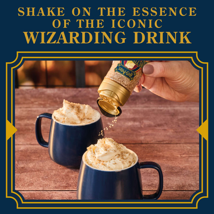 A hand shakes Harry Potter Butterbeer shimmer topping onto mugs of whipped cream, suggesting a magical beverage experience.