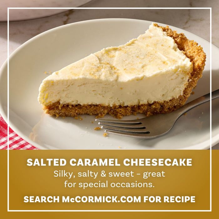 A slice of silky salted caramel cheesecake with a thick graham cracker crust is presented on a white plate as a serving suggestion for Mccormick Salted Caramel Cheesecake Seasoning Mix, 1.62 Oz.