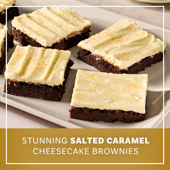 A white platter holds several square brownies topped with a thick layer of frosting made using Mccormick Salted Caramel Cheesecake Seasoning Mix 1.62 Oz and finished with a sprinkle of coarse sugar.