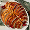 A platter of succulent sliced turkey breast seasoned with Mccormick Turkey Rub, 1.25 Oz and garnished with fresh cranberries.