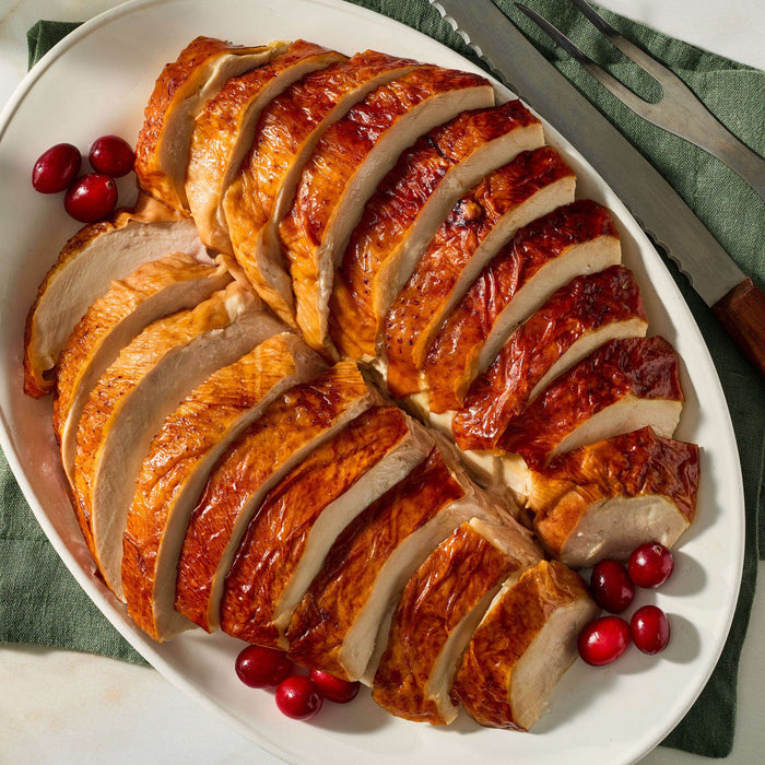 A platter of succulent sliced turkey breast seasoned with Mccormick Turkey Rub, 1.25 Oz and garnished with fresh cranberries.