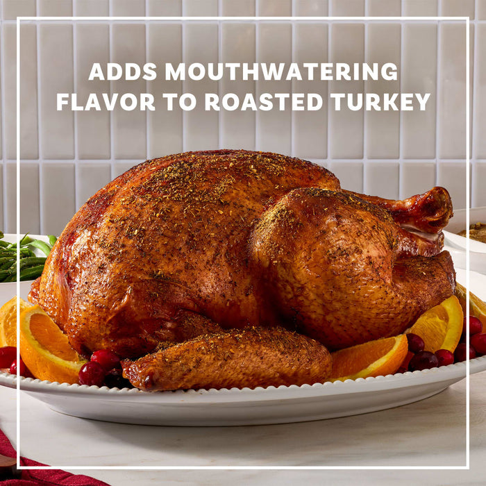 A golden brown roasted turkey seasoned with Mccormick Turkey Rub, 1.25 Oz is presented on a white platter garnished with orange slices and cranberries.