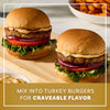 Two juicy turkey burgers stacked with lettuce, tomato, and red onion are served on a wooden board to showcase how to use Mccormick Turkey Rub, 1.25 Oz for craveable flavor.