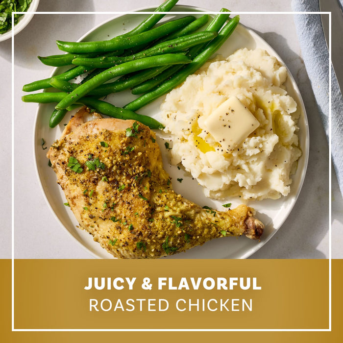 A plated meal featuring a leg of juicy and flavorful roasted chicken seasoned with Mccormick Garlic And Herb Butter Roast Seasoning Mix 1.0 Oz served alongside creamy mashed potatoes with a pat of butter and fresh green beans.