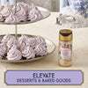 A two-tiered dessert stand displays lavender-colored meringue cookies next to a bottle of McCormick Lavender Sugar, highlighting the product's use in elevating desserts and baked goods.