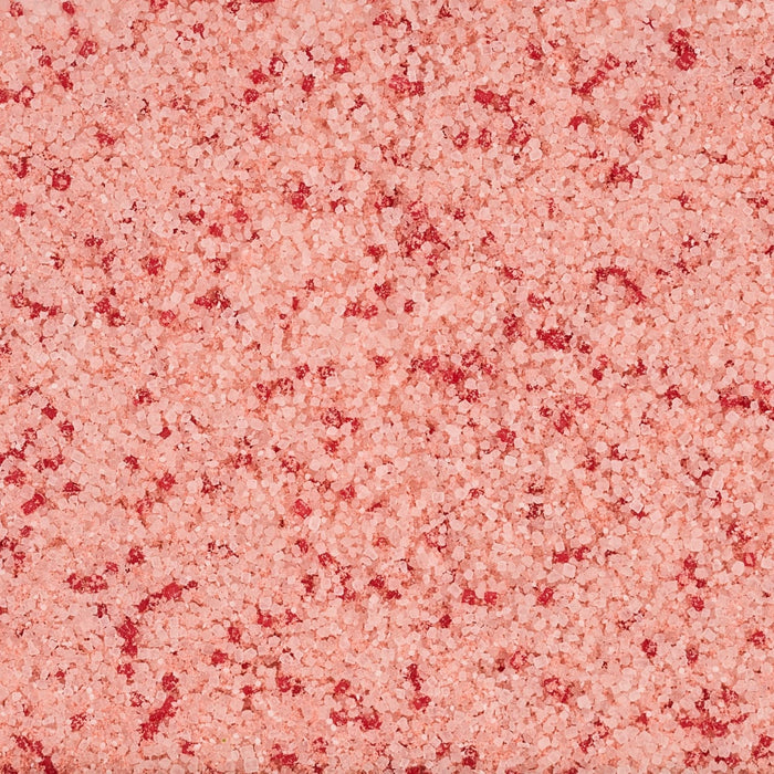 A close-up texture of a pink bath bomb with darker pink speckles.