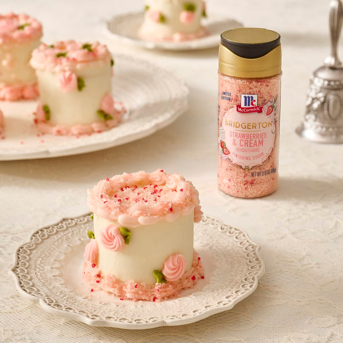 A close-up shows mini cakes decorated with pink frosting and McCormick Rose Flavor Sugar Sprinkles.